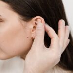 doctor examines girl ears before otoplasty
