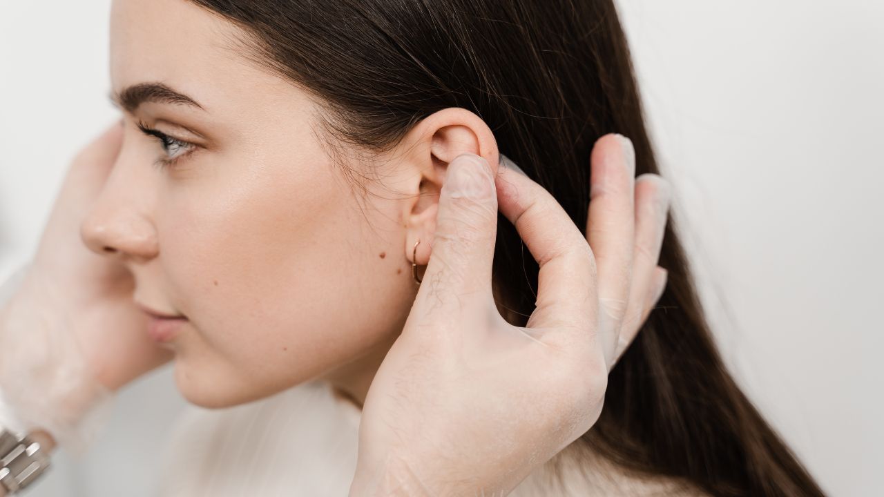 doctor examines girl ears before otoplasty